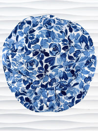 Euro Pixie style surgical scrub cap by JensCaps with flowers in varying shades of blue with a white background displayed on a white mannequin head.