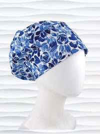 Euro Pixie style surgical scrub cap by JensCaps with flowers in varying shades of blue with a white background displayed on a white mannequin head.