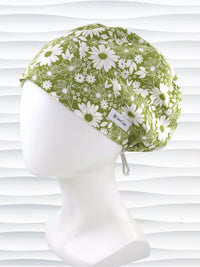 Euro Pixie style surgical scrub cap by JensCaps with white daisies and flowers all over a light green background cotton fabric and displayed on a mannequin head.