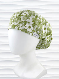 Bouffant style surgical scrub cap by JensCaps with white daisies and flowers all over a light green background cotton fabric and displayed on a mannequin head.