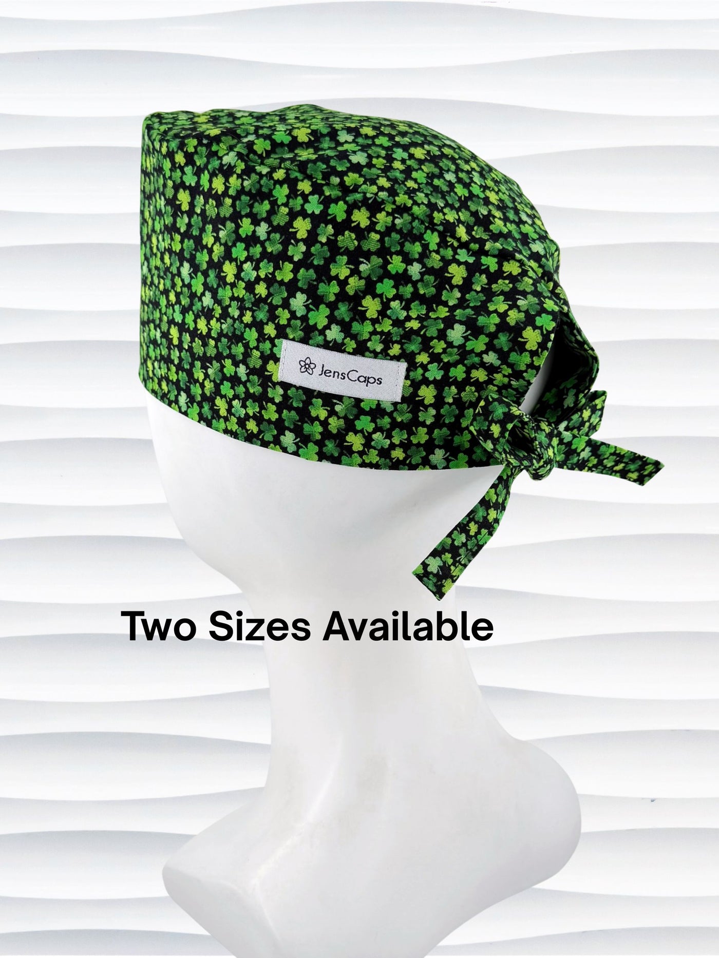 Mens style surgial scrub cap with small greencshamrocks on black cotton fabric and displayed on mannequin head.