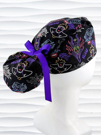 Ponytail style surgical scrub cap with neon colors of iconic villains all over black cotton fabric, finished with a ribbon tie and displayed on mannequin head.