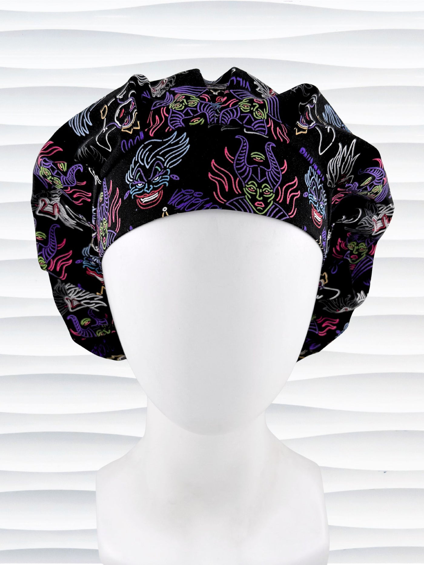 Bouffant style surgical scrub cap with neon colors of iconic villains all over black cotton fabric and displayed on mannequin head.