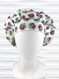 Bouffant style surgical scrub cap by JensCaps with red cherries and blue polka dots on white cotton fabric and displayed on a mannequin head.
