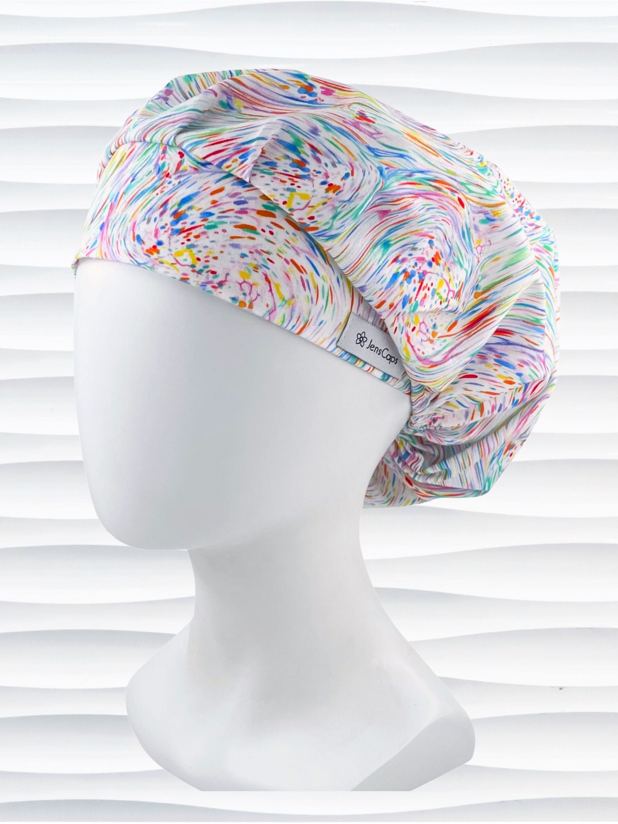 Bouffant style surgical scrub cap hat with pastel oil slick swirls all over this white cotton fabric.