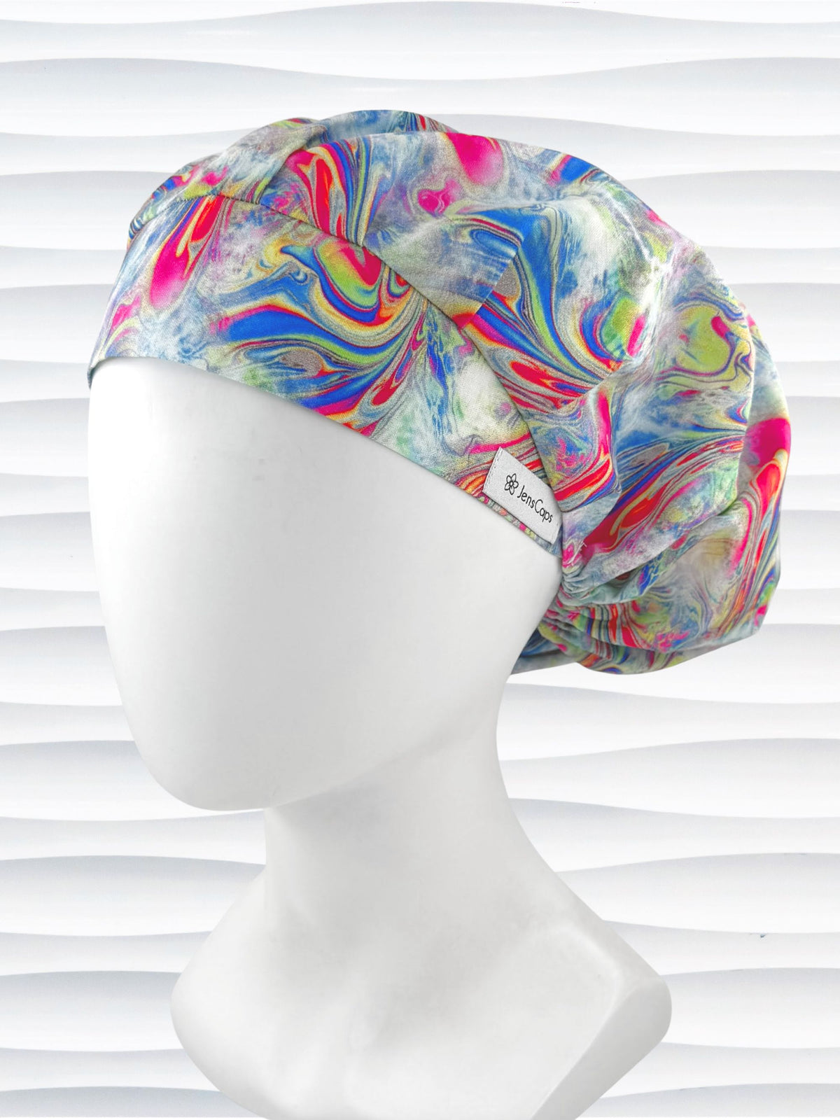 Bouffant style surgical scrub cap by JensCaps with an abstract marbled swirl print in blue, pink, yellow, and green, and displayed on a white mannequin head.