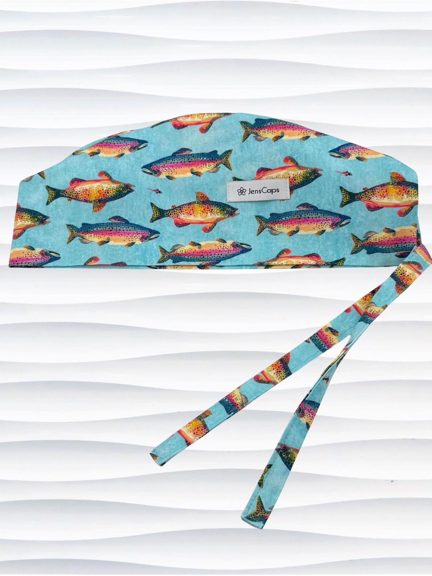Tie back style surgical scrub cap by JensCaps with colorful fish on a light blue fabric