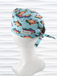Tie back style surgical scrub cap by JensCaps with colorful fish on a light blue fabric and displayed on a white mannequin head