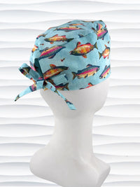 Tie back style surgical scrub cap by JensCaps with colorful fish on a light blue fabric and displayed on a white mannequin head
