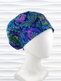 Euro Pixie style surgical scrub cap by JensCaps with an allover floral pattern in dark blue, purple, emerald, and turquoise and displayed on a mannequin head.