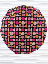 Bouffant style surgical scrub cap by JensCaps with pink and orange pumpkins on black cotton fabric and displayed on a mannequin head.
