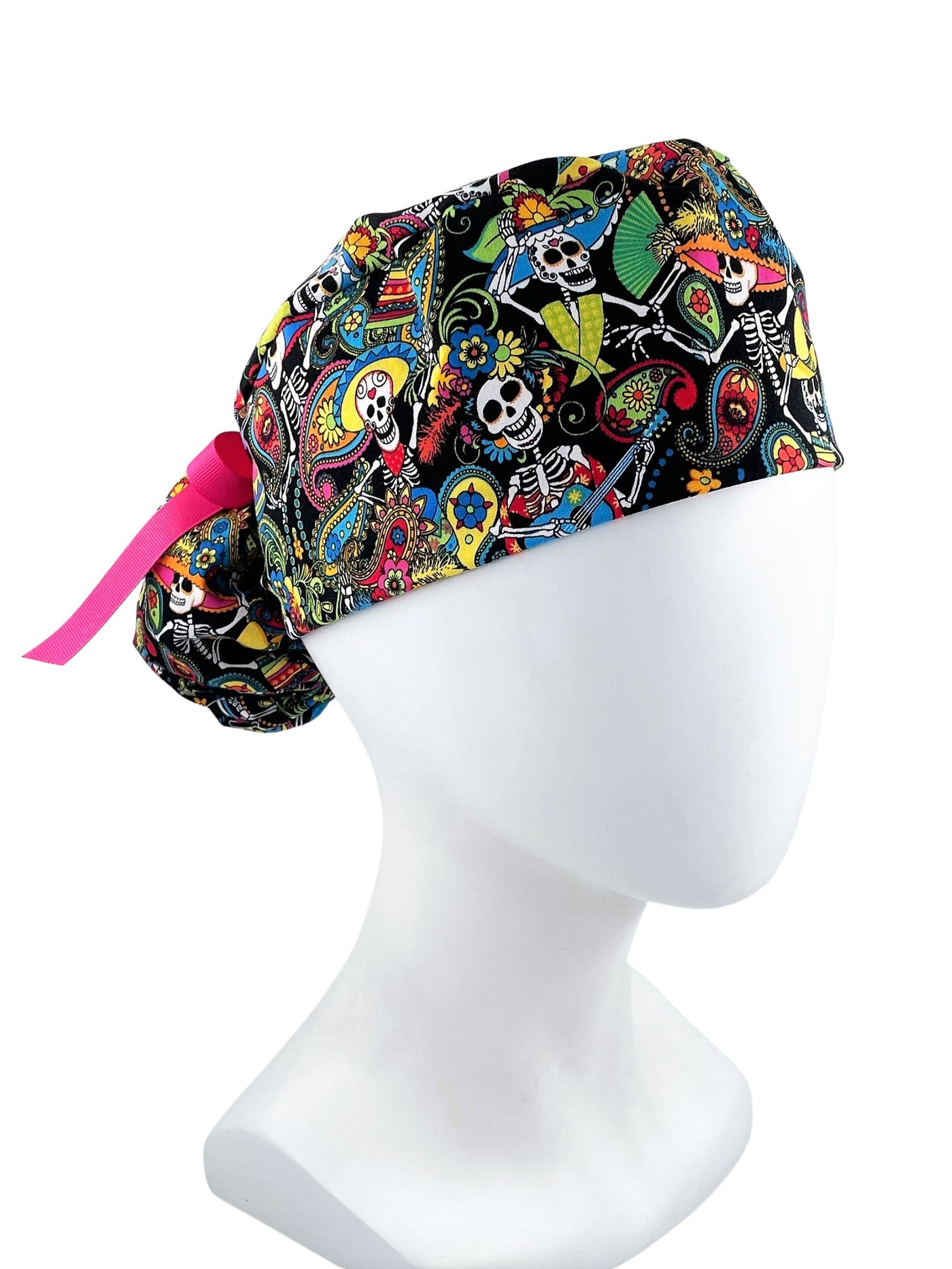 Ponytail scrub cap hat with day of the dead in bright colors on black cotton fabric and finished with grosgrain ribbon ties.