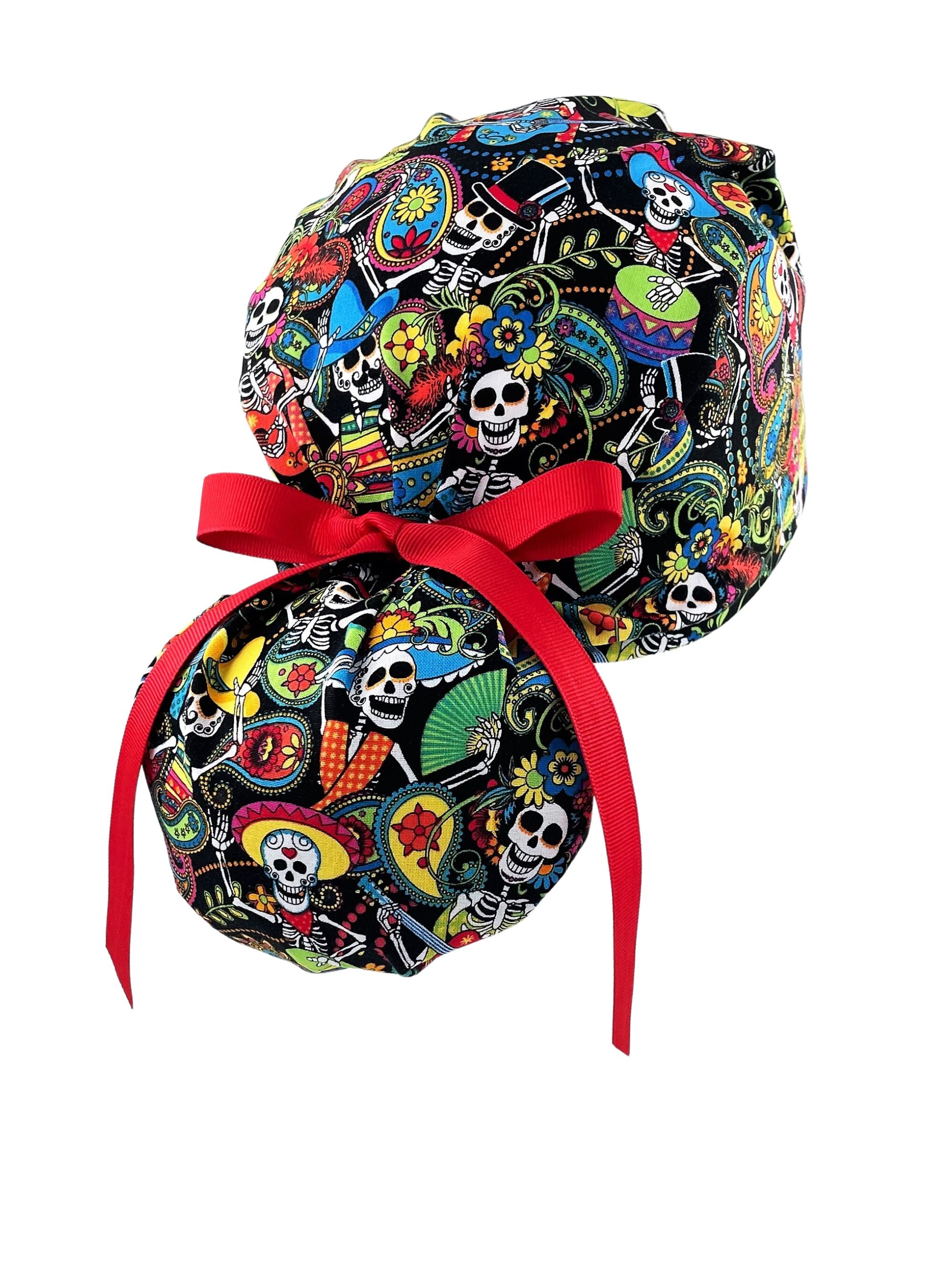 Ponytail scrub cap hat with day of the dead in bright colors on black cotton fabric and finished with grosgrain ribbon ties.