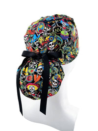 Ponytail scrub cap hat with day of the dead in bright colors on black cotton fabric and finished with grosgrain ribbon ties.
