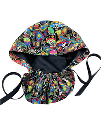 Ponytail scrub cap hat with day of the dead in bright colors on black cotton fabric and finished with grosgrain ribbon ties.