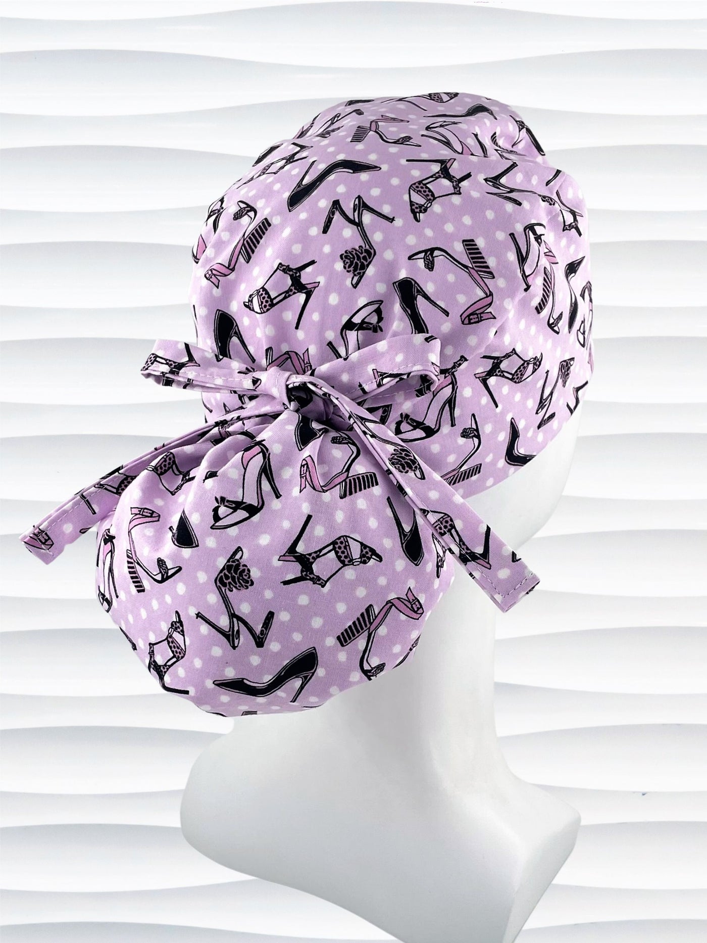 Ponytail style scrub cap hat with pink and black high heel shoes and white dots on pink cotton fabric.