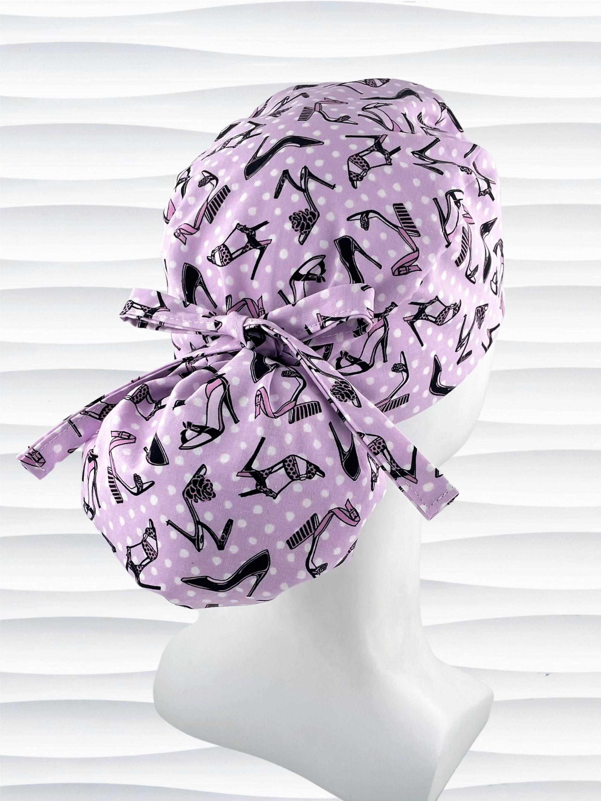 Ponytail style scrub cap hat with pink and black high heel shoes and white dots on pink cotton fabric.