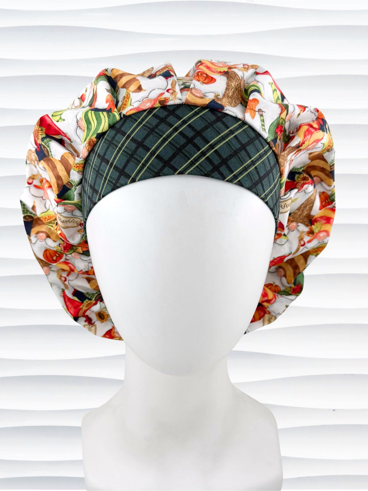 Bouffant style surgical scrub cap with gnomes in fall colors holding sunflowers and signs that say thankful, a dark green plaid front, and displayed on a mannequin head.