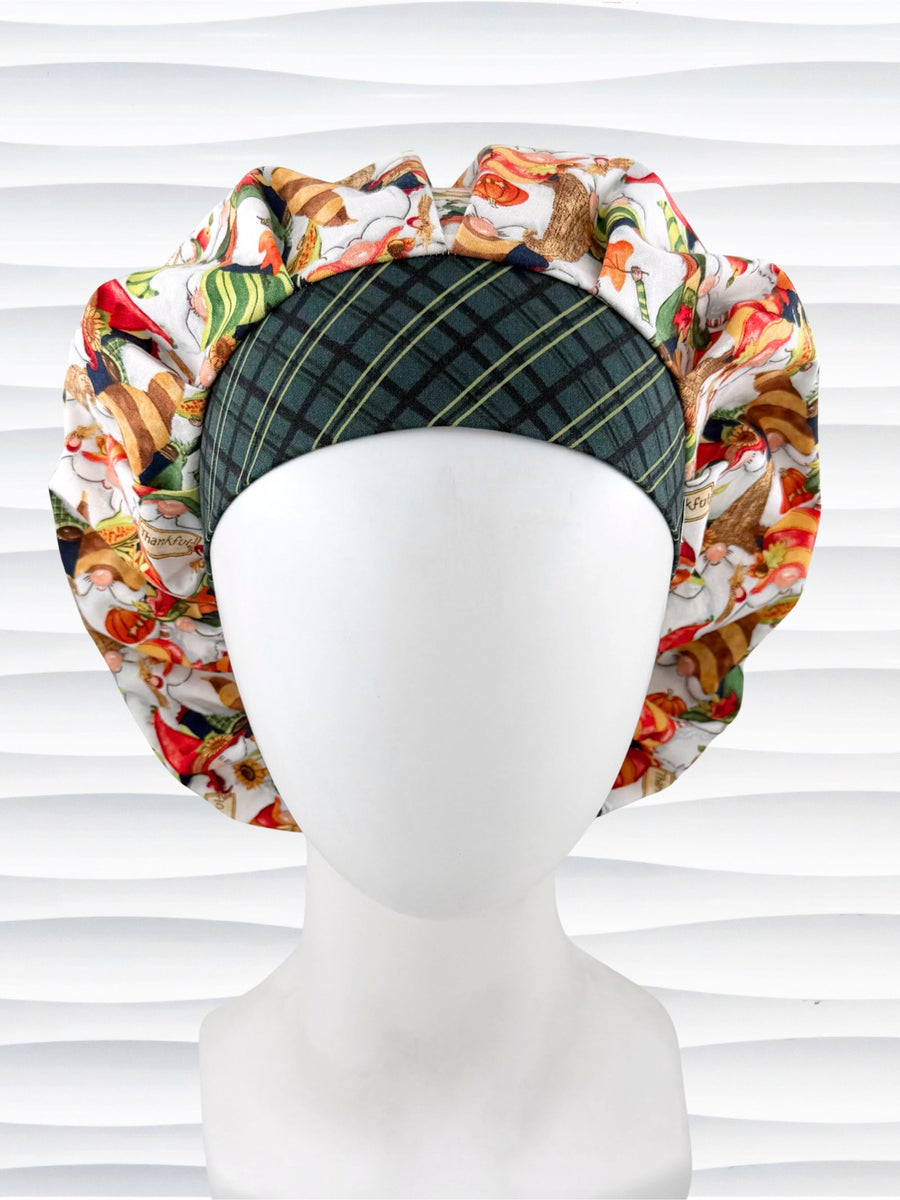 Bouffant style surgical scrub cap with gnomes in fall colors holding sunflowers and signs that say thankful, a dark green plaid front, and displayed on a mannequin head.