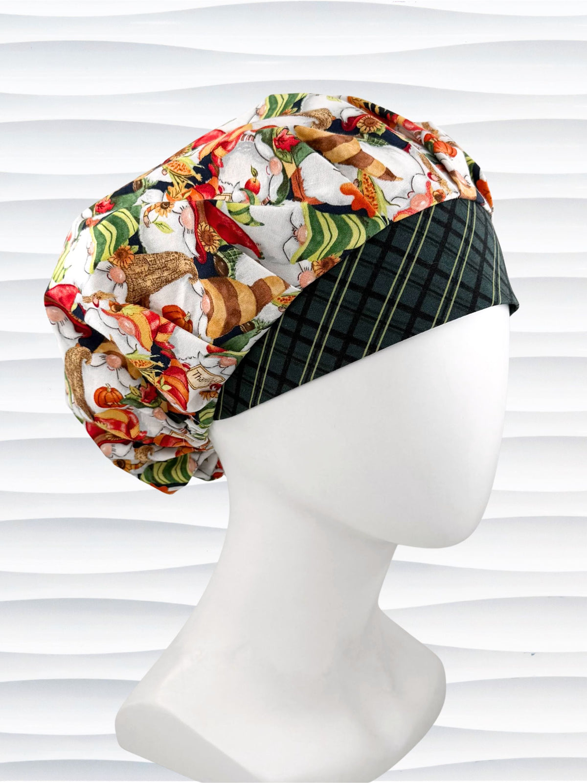 Bouffant style surgical scrub cap with gnomes in fall colors holding sunflowers and signs that say thankful, a dark green plaid front, and displayed on a mannequin head.