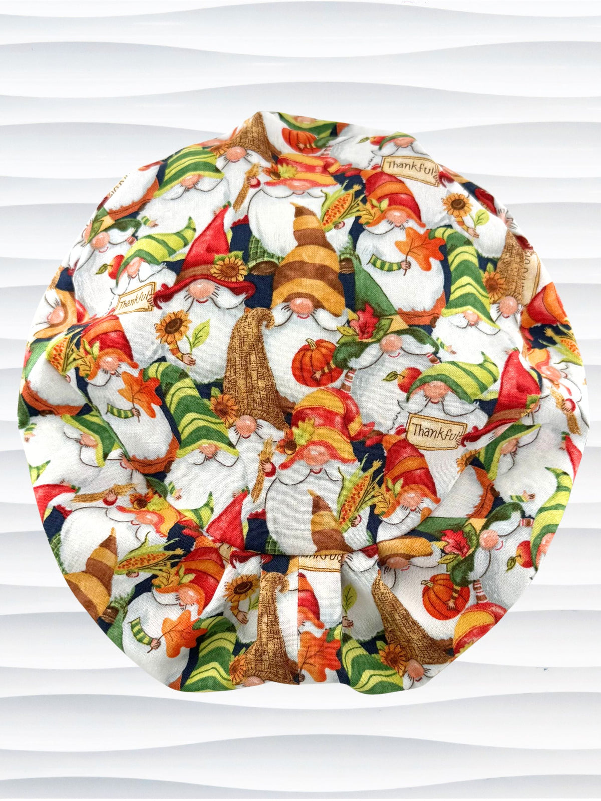 Euro Pony style surgical scrub cap with gnomes in fall colors holding sunflowers and signs that say thankful and displayed on a mannequin head.