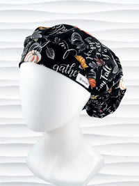 Bouffant style surgical scrub cap hat with pumpkins, sunflowers, and words about Thanksgiving on black cotton fabric. Happy Fall Y'all