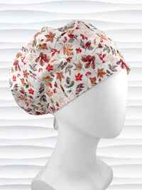 Euro Pixie style surgical scrub cap with an assortment of autumn eaves in fall colors all over a light background and displayed on a white mannequin head.