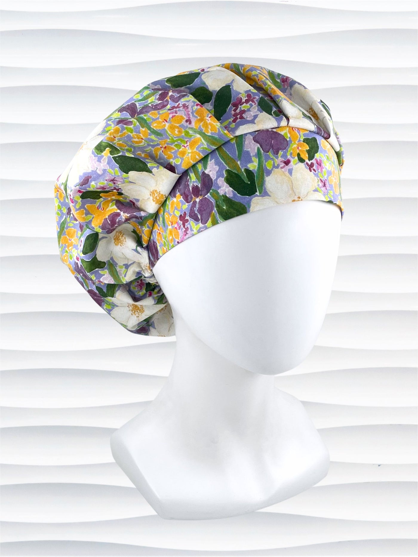 Bouffant style surgical scrub cap hat with Mardi Gras colors of yellows, greens, and purples on white cotton fabric.