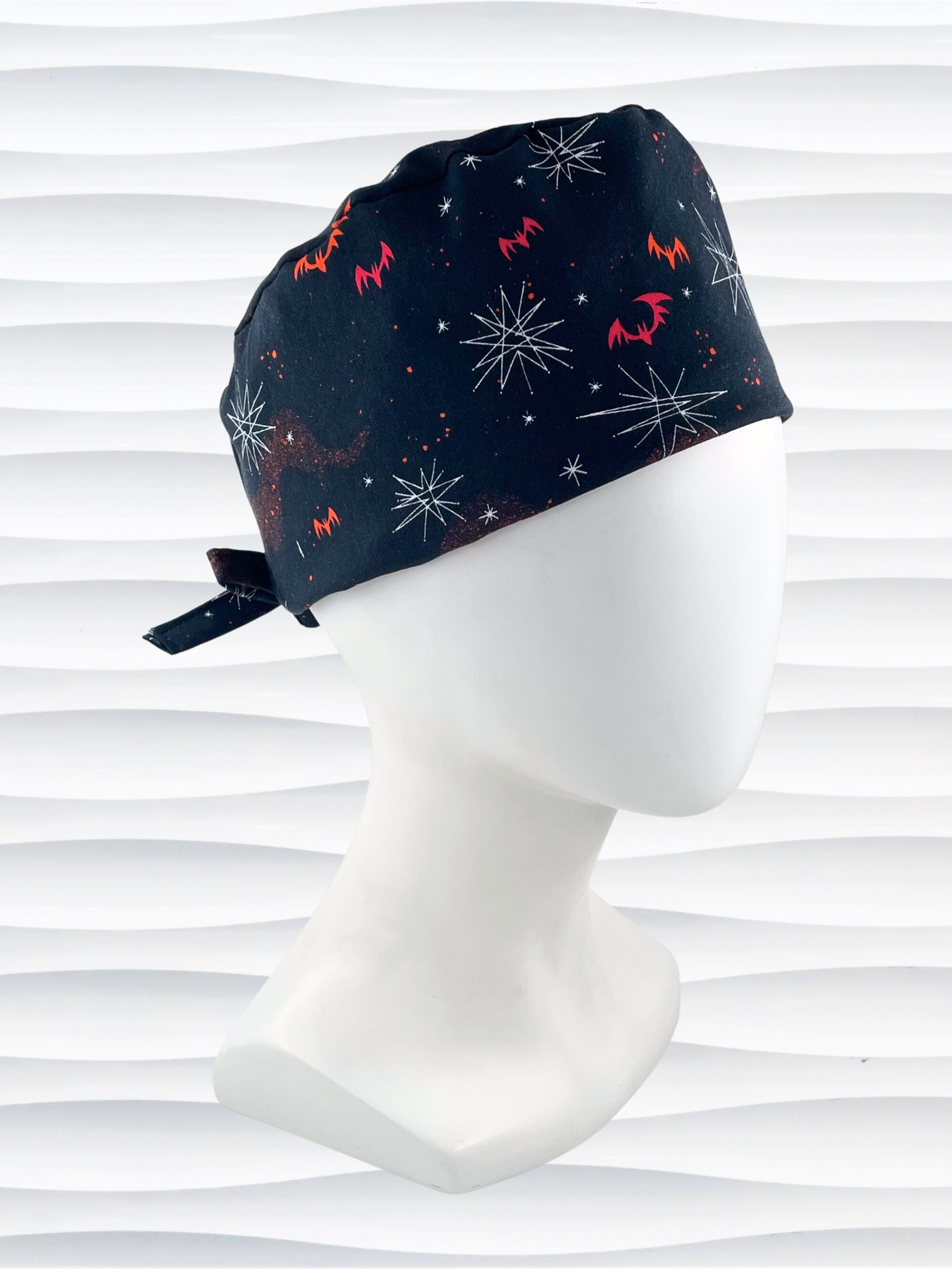 Surgeon style men's surgical scrub cap hat with red and orange bats and white stars on black cotton fabric.