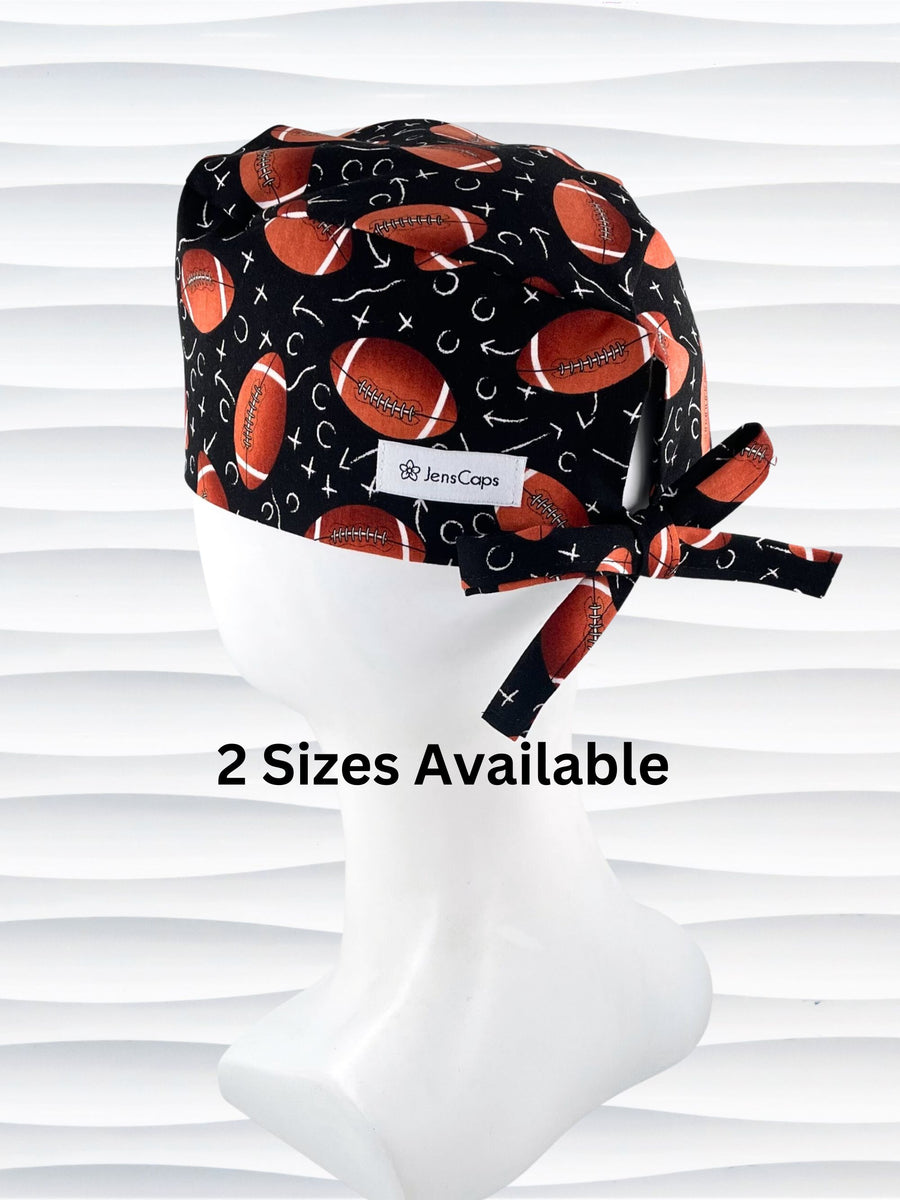 Surgeon style surgical scrub cap hat with footballs and Xs and Os tossed all over this black cotton premium fabric.