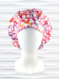 Bouffant style surgical scrub cap by JensCaps with watercolor hearts in pastel colors all over white cotton fabric and dispoayed on a white mannequin head.