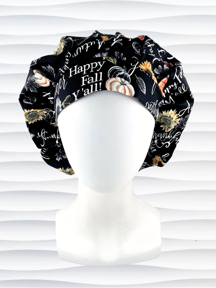 Bouffant style surgical scrub cap hat with pumpkins, sunflowers, and words about Thanksgiving on black cotton fabric. Happy Fall Y'all