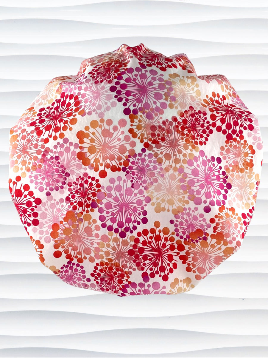Bouffant style scrub cap with pink and red and orange allium flowers on white cotton fabric