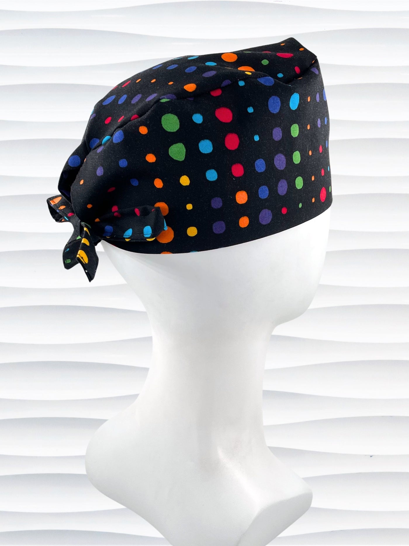 Surgeon style surgical scrub cap hat with bright colored linear dots on black cotton fabric.