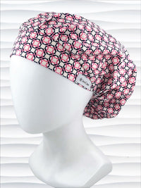 Bouffant style surgical scrub cap hat with pink and blue circles and squares in a trellis pattern on cotton fabric.